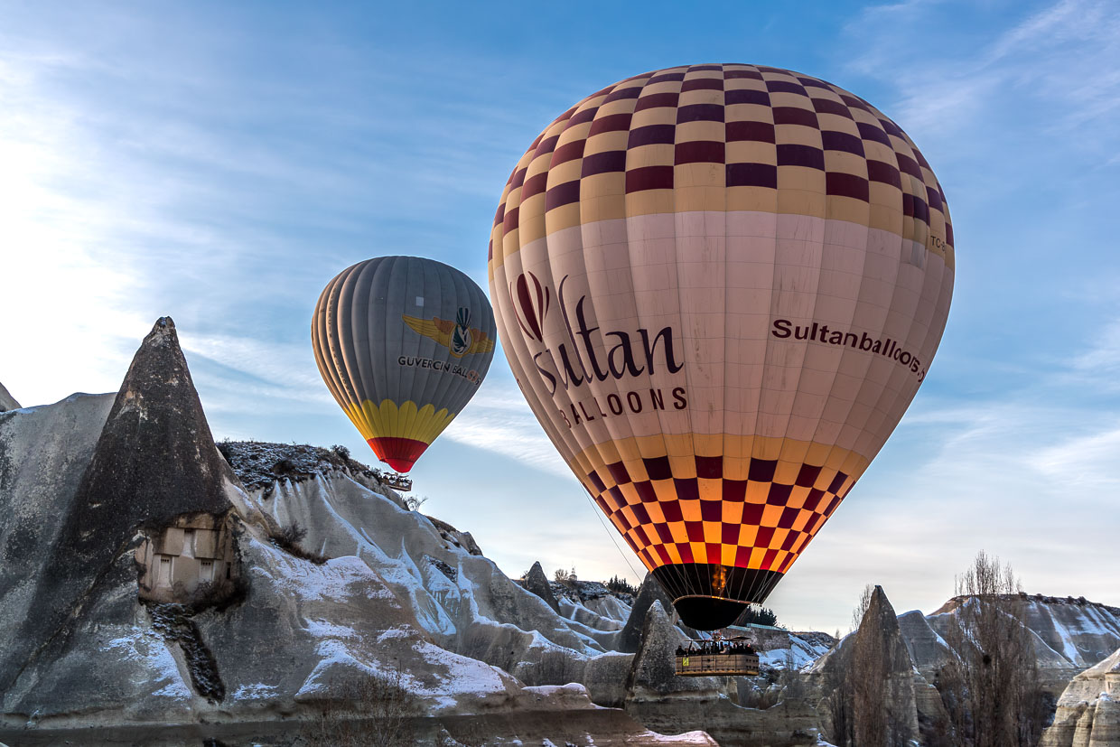 Heißluftballons zwischen den Felsformationen von Göreme. Einige Feenkamine der Tuffsteinlandschaft sind bewohnt / © Foto: Georg Berg