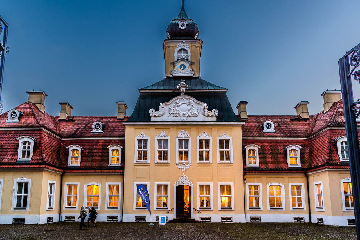 Zwei Personen gehen am Abend am Palais Augusteum, Leipzig, Germany vorbei