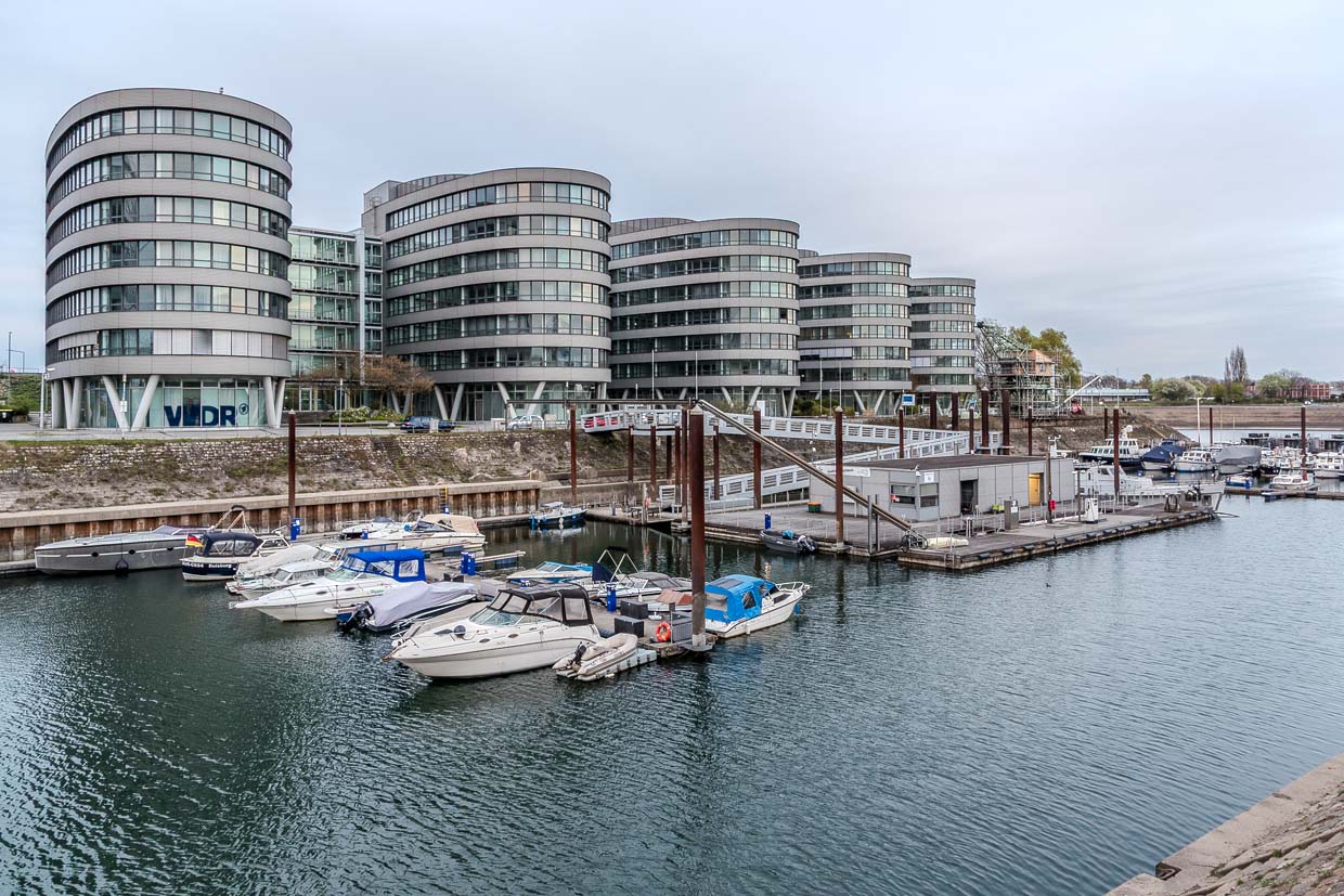 Mehrere Boote liegen im Hafen vor modernen Bürogebäuden in Duisburg, Germany
