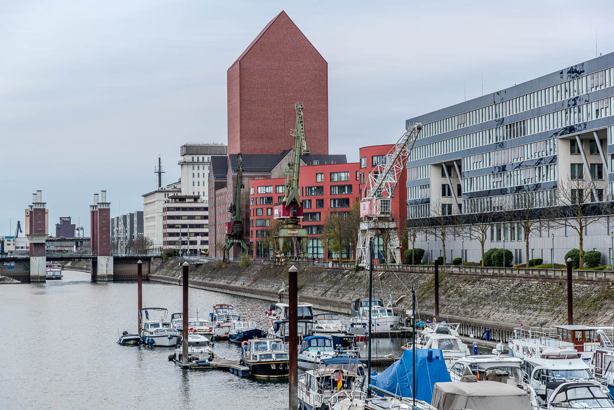 Duisburger Innenhafen mit Landesarchiv NRW. Es entstand ab 2008 durch Umbau eines historischen Speichers. Der Neubau kombiniert den denkmalgeschützten Speicher von 1936 mit einem 77 Meter hohen Archivturm und einem wellenförmigen 160 Meter langen orangefarbigen Anbau / © Foto: Georg Berg