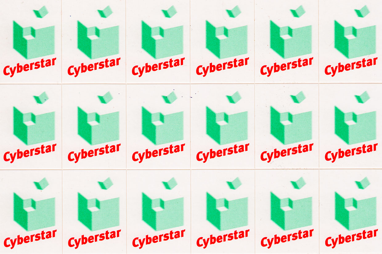 Cyberstar-Logo:Cyberstar-Schriftzug und grüner Würfel, aus dessen Ecke ein kleiner grüner Würfel davonfliegt