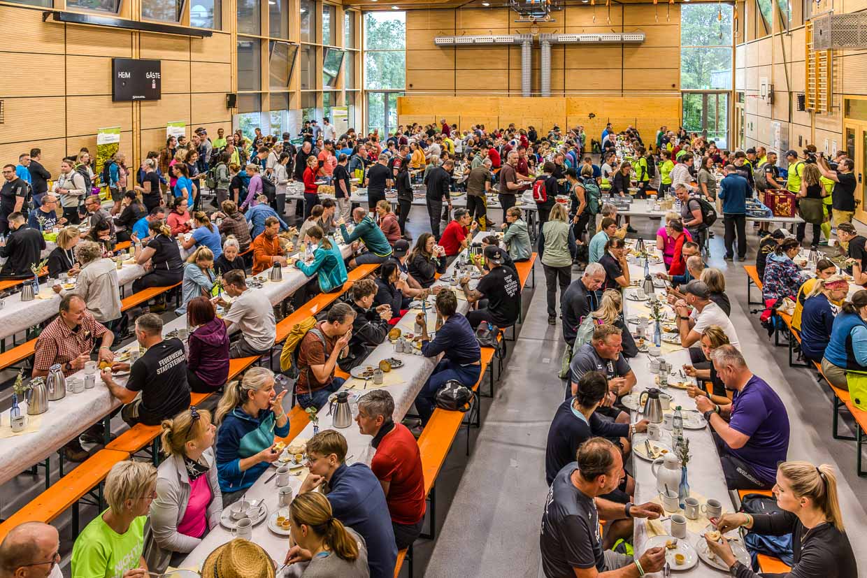 Zahlreiche Teilnehmer frühstücken gemeinsam an langen Tischen in einer Halle an der Edwin-Trebes-Straße, Steinbach am Wald, Germany