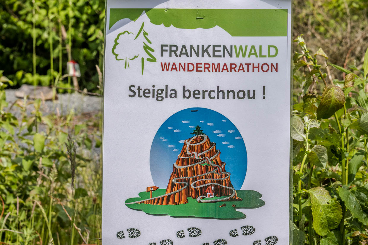 Schild des Frankenwald Wandermarathons mit Bergillustration und Spruch 'Steigla berchnou' in KC 9 Pressig Germany
