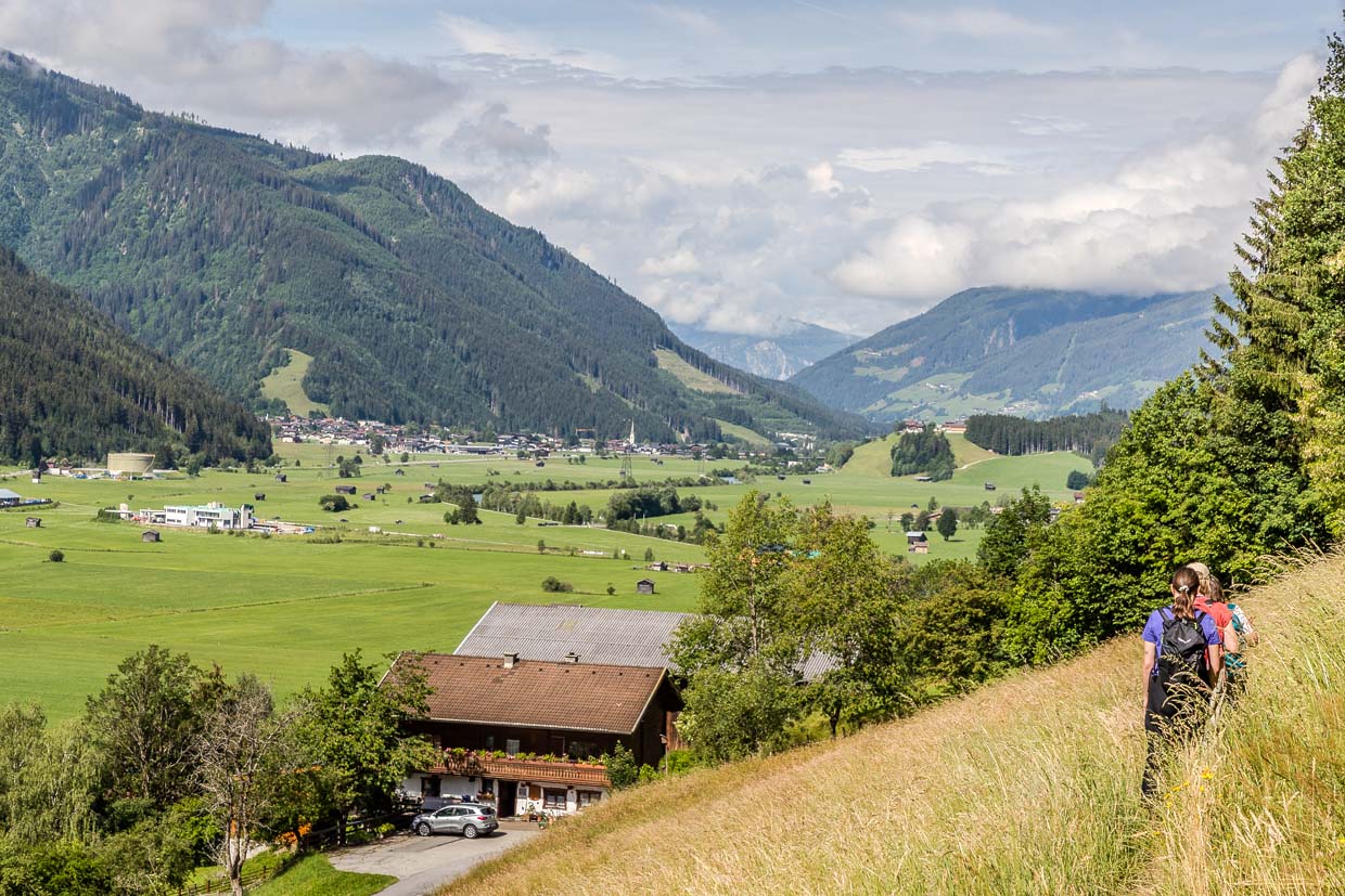 Wanderer wandern einen Grashang hinauf mit Panoramablick auf das Tal von Mittersill und die Berge am Wachtlehenweg Mittersill Austria