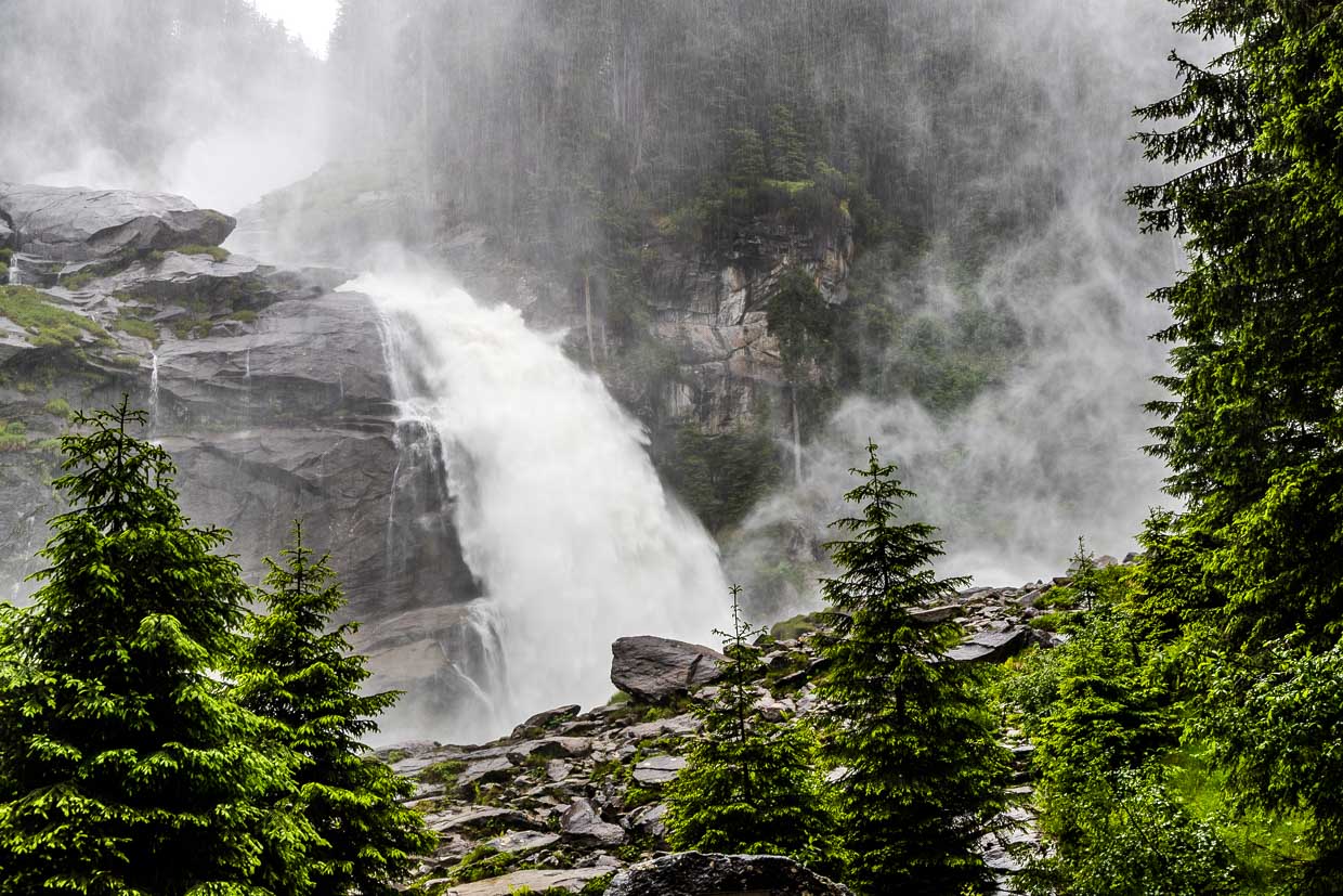 Ein mächtiger Wasserfall stürzt über felsige Kaskaden am Wasserfallweg Krimml Austria umgeben von üppiger Natur