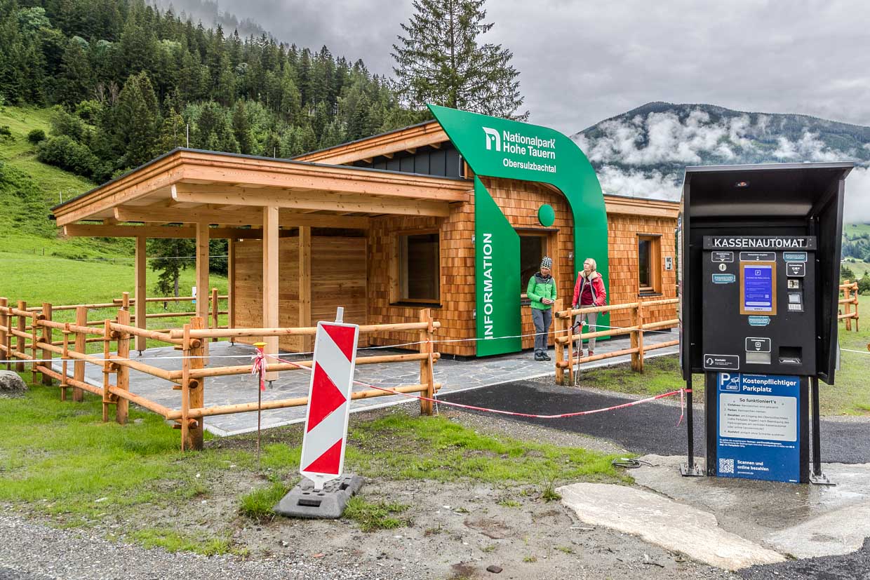 Zwei Frauen stehen vor dem Informationsgebäude des Nationalparks Hohe Tauern Obersulzbachtal und einem Kassenautomat an der Mittergasse in Rosental Austria