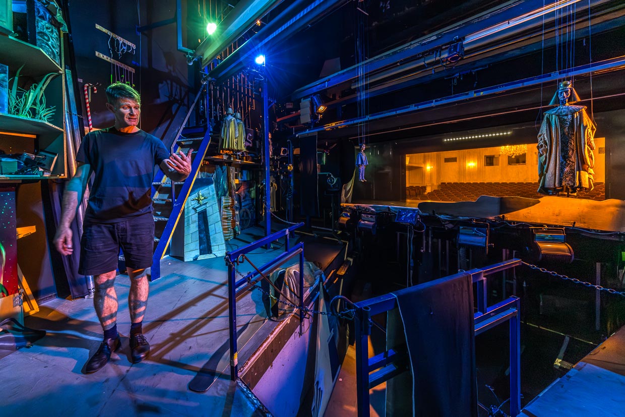 Ein Mann zeigt Theaterrequisiten und Bühnentechnik hinter der Bühne in der Schwarzstraße Salzburg Austria