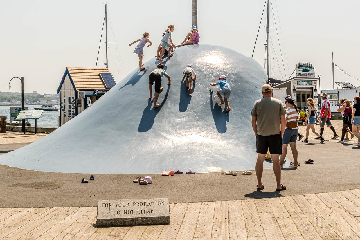 Kinder klettern auf einer blauen Skulptur am Halifax Waterfront Boardwalk, Halifax, Canada