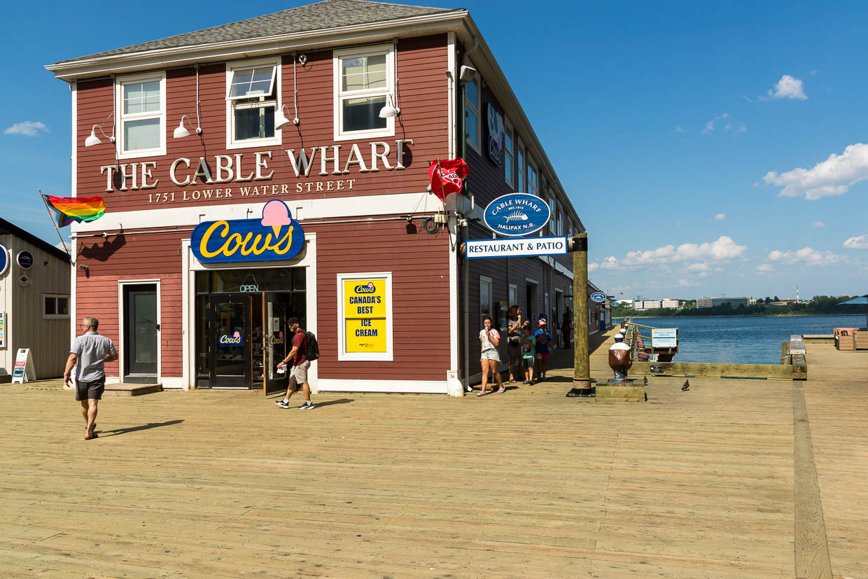 Menschen genießen Eiscreme und Restaurants am Halifax Waterfront Boardwalk in Halifax, Kanada