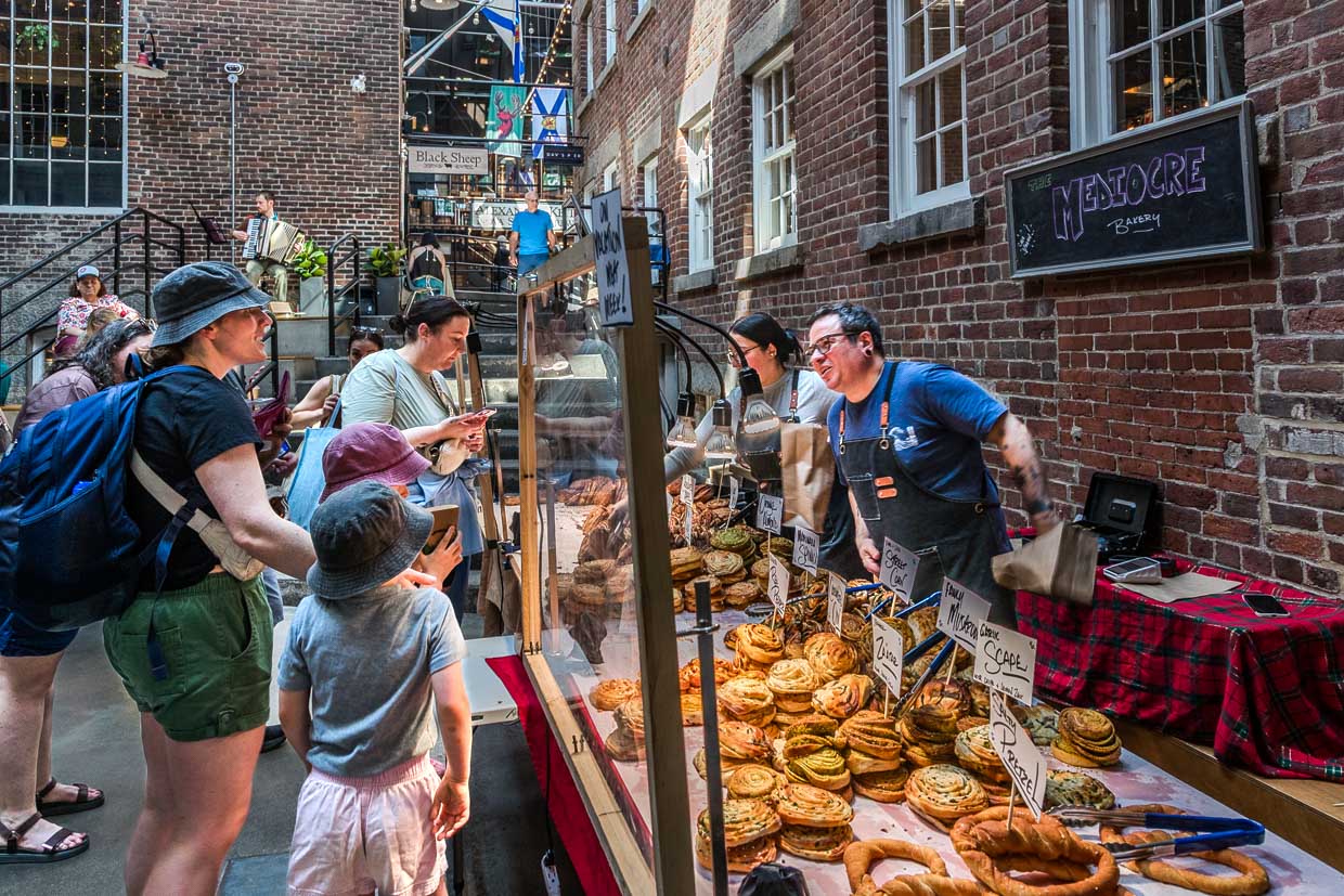 Verkäufer bedienen Kunden mit Gebäck am Marktstand in Halifax, Canada