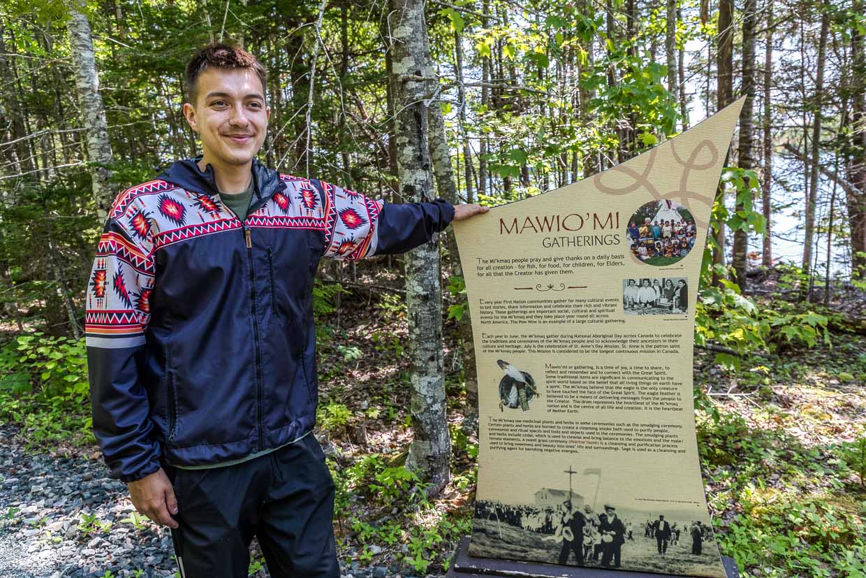 Ein Mann steht neben einem Informationsschild über Mi'kmaq-Kultur am Goat Island Trail, Eskasoni First Nation, Canada
