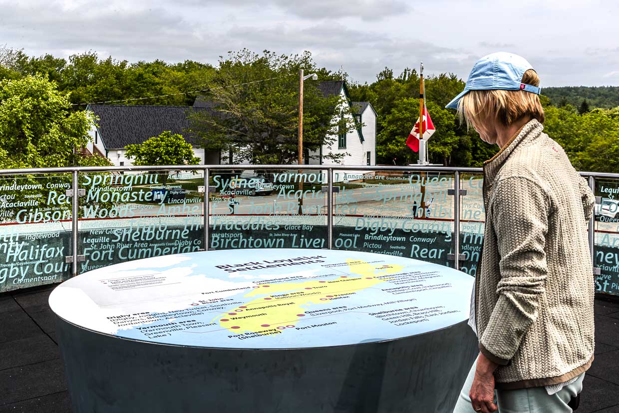 Frau betrachtet Informationstafel über Black Loyalist Settlements an Birchtown Road, Municipality of the District of Shelburne, Canada