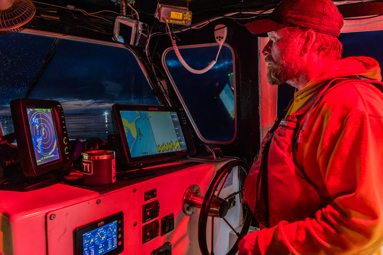 Mann steuert Boot mit Navigationsgeräten an Bord auf Murray Road, Murray, Canada
