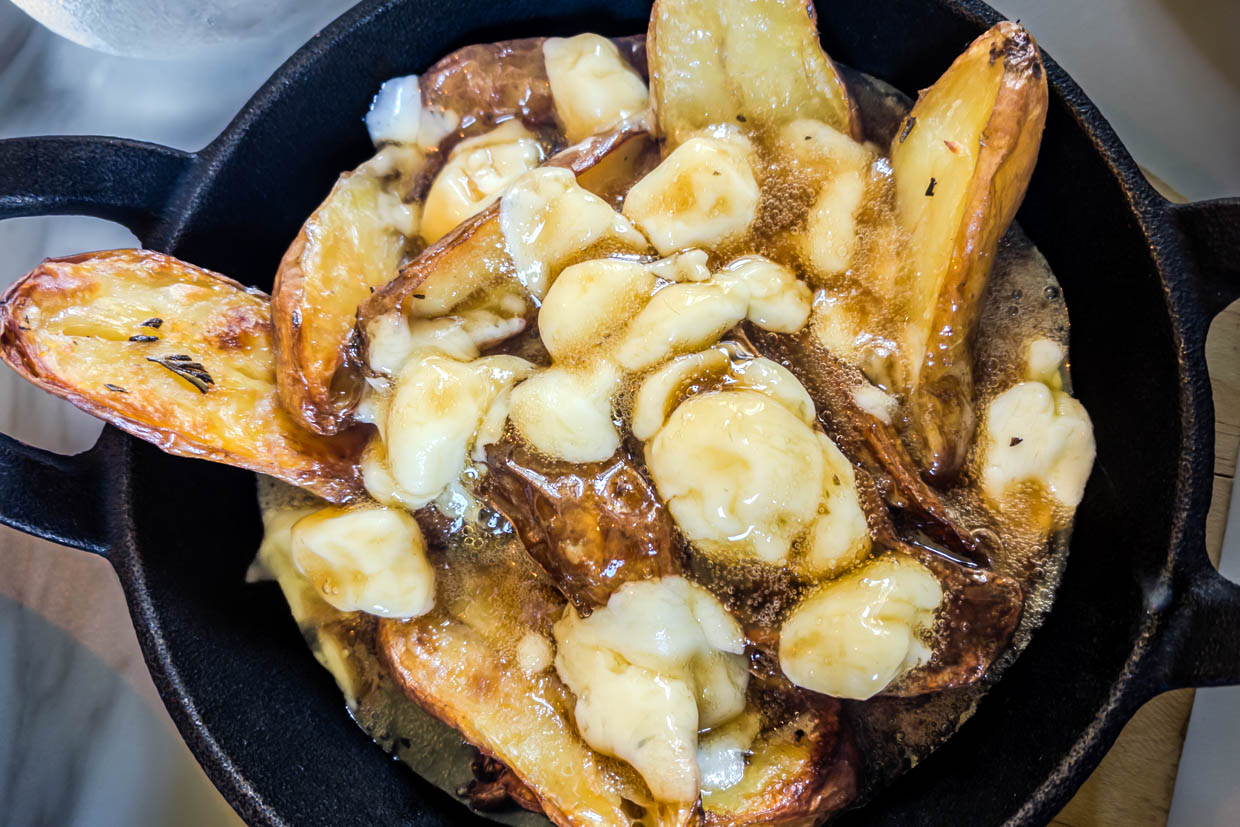 Poutine mit geschmolzenem Käse und Bratensauce in einer Pfanne in Annapolis Royal Heritage Area, Kanada