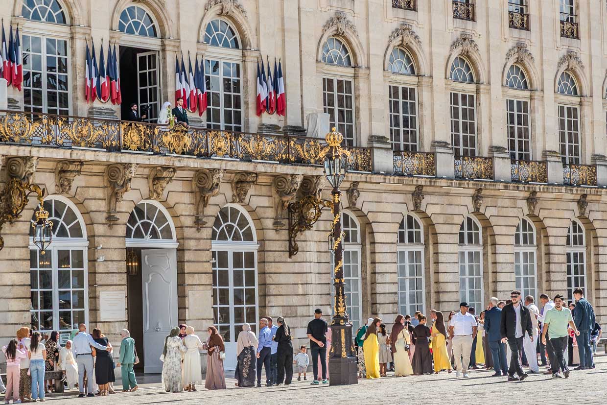 Menschen versammeln sich vor einem Gebäude mit französischen Flaggen an der Rue Sainte-Catherine, Nancy, France